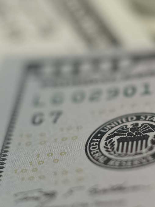 creative shot of Federal Reserve seal on money